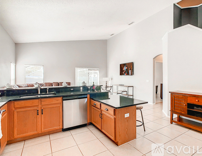 A kitchen with wooden cabinets and a black countertop.