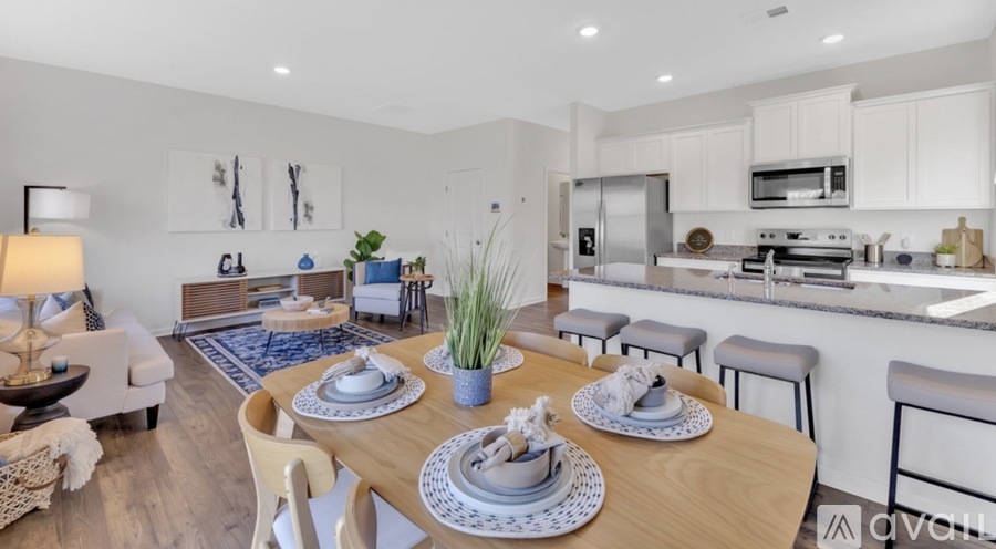 A modern kitchen and dining area with a table set for two.