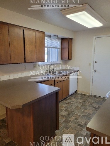 A kitchen with wooden cabinets and a countertop is available for rent.