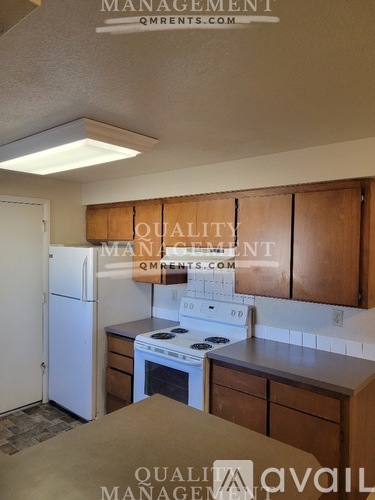 A kitchen with a refrigerator, oven, and cabinets.