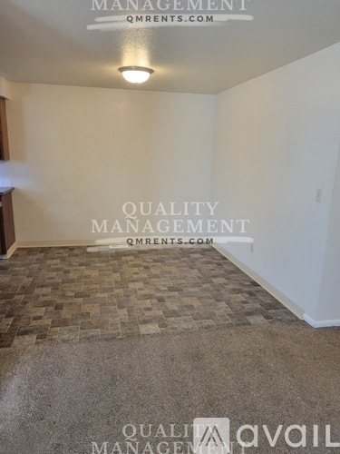 A room with a tiled floor and a text that reads "QUALITY MANAGEMENT QMRENTS.COM".