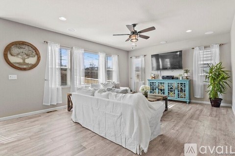 A bedroom with a large bed and a ceiling fan.