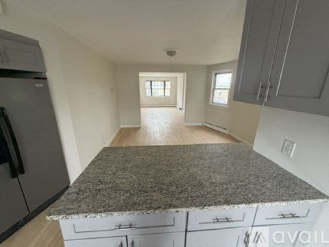 A kitchen with granite countertops and white cabinets.