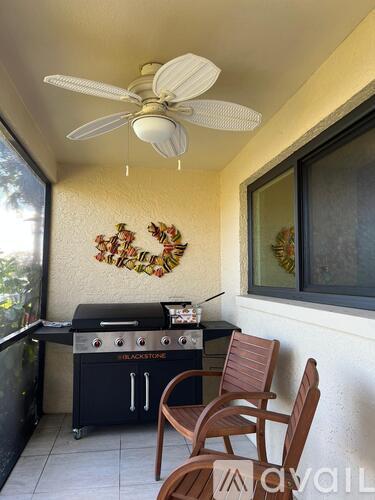 A patio with a grill and chairs.