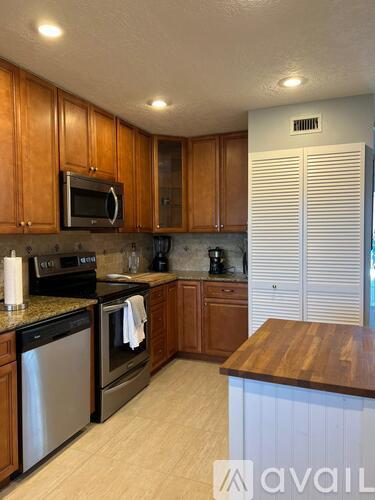 A kitchen with wooden cabinets and a stainless steel dishwasher.
