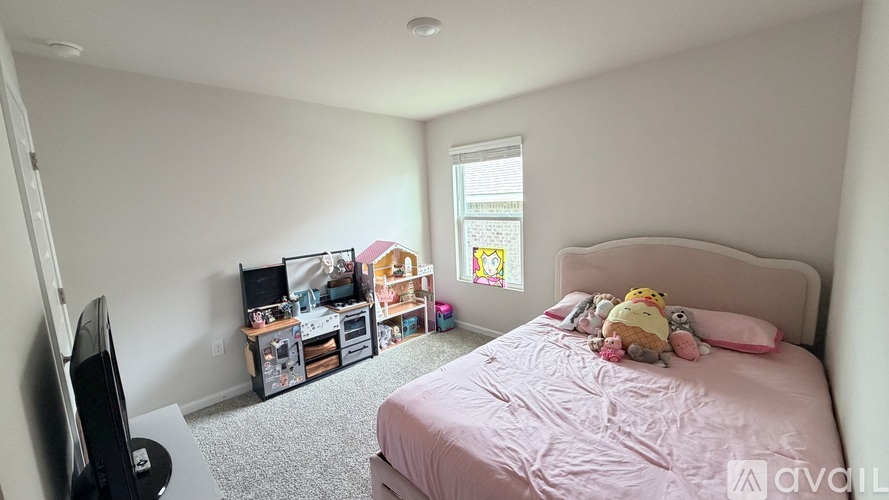 A bedroom with a bed, a television, and a window with a view of a colorful building.
