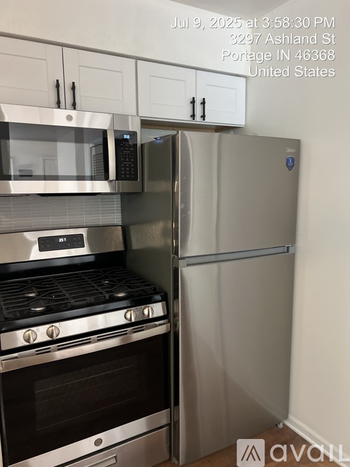 A kitchen with a stove, microwave, and refrigerator.