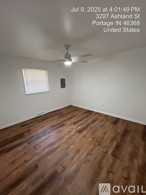 A room with wooden flooring and a ceiling fan.