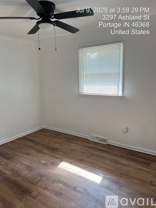 A room with a ceiling fan and wooden flooring.