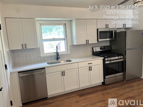 A kitchen with white cabinets and stainless steel appliances.