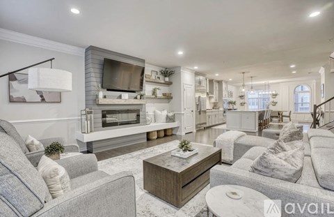 A modern living room with a grey sofa set and a television.