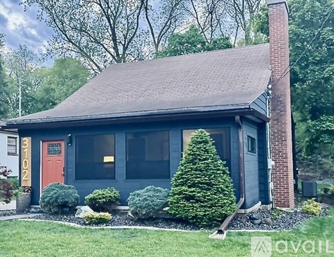 A house with a red door and a brick chimney.