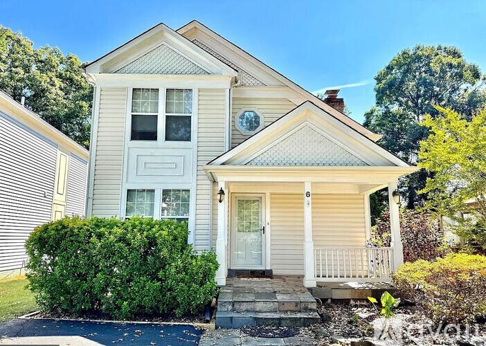 A small house with a front porch and a white door.