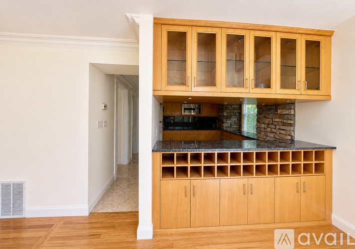 A kitchen with wooden cabinets and a stone counter.