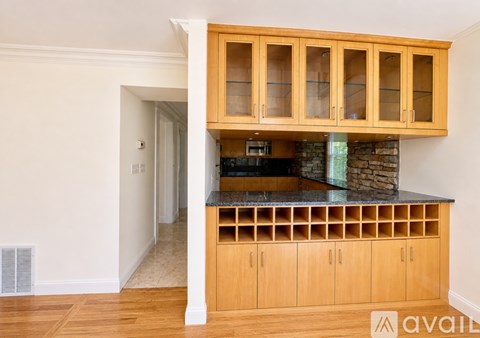 A kitchen with wooden cabinets and a stone counter.