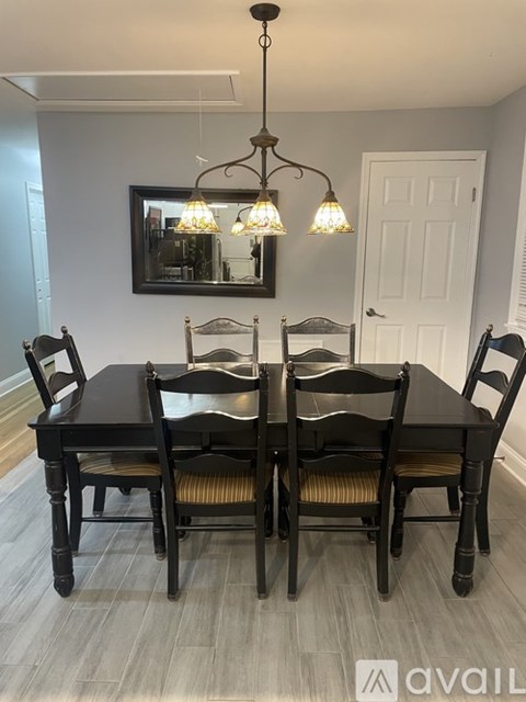 A dining room with a table and chairs.