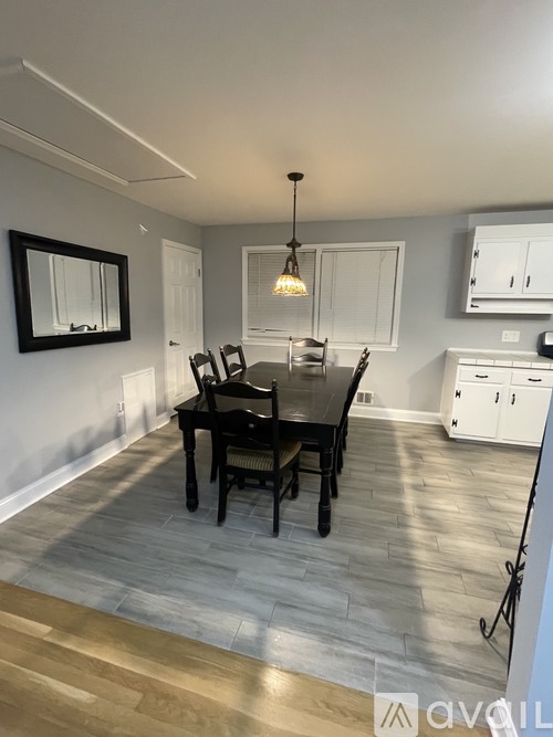 A dining room with a table and chairs.