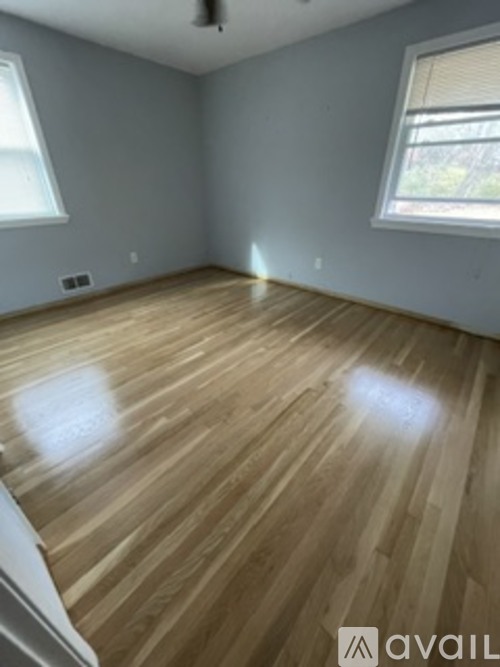 A room with wooden flooring and a window.