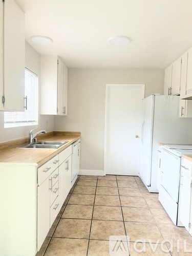 A kitchen with white cabinets and a tiled floor.
