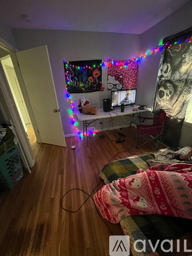 A room with a desk, computer, and Christmas lights.