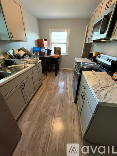 A kitchen with wooden floors and a countertop with a microwave on it.