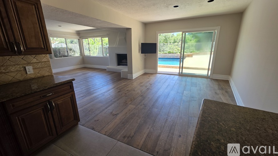 A spacious living room with wooden floors and a television.