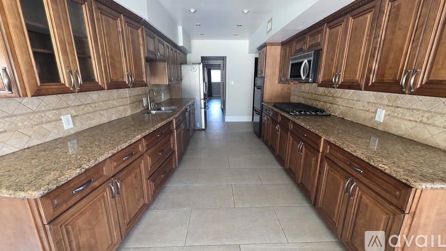 A kitchen with brown cabinets and granite countertops is available.