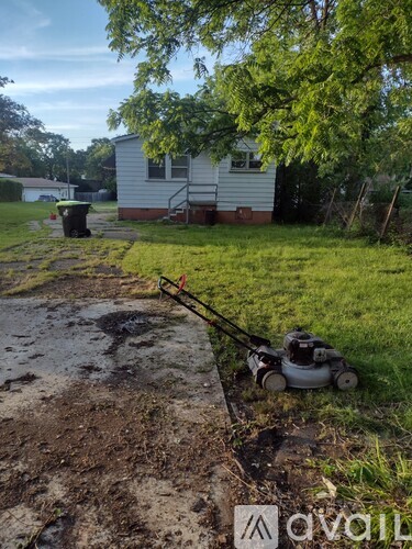A lawn mower is on the ground next to a muddy path.