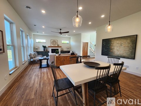 A modern living room with a dining table set up with chairs.