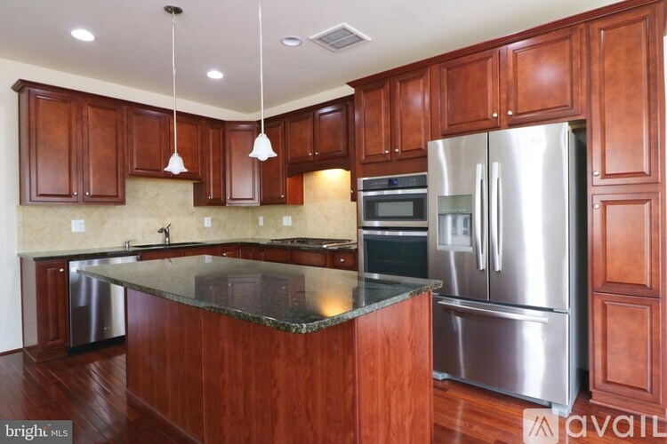 A kitchen with wooden cabinets and a stainless steel refrigerator.