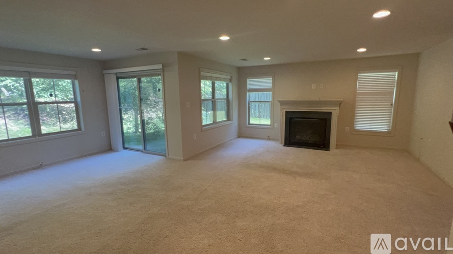 A spacious living room with a fireplace and large windows.