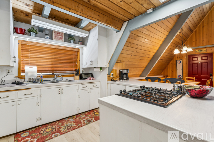 A kitchen with white cabinets and a wooden ceiling.