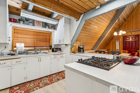 A kitchen with white cabinets and a wooden ceiling.