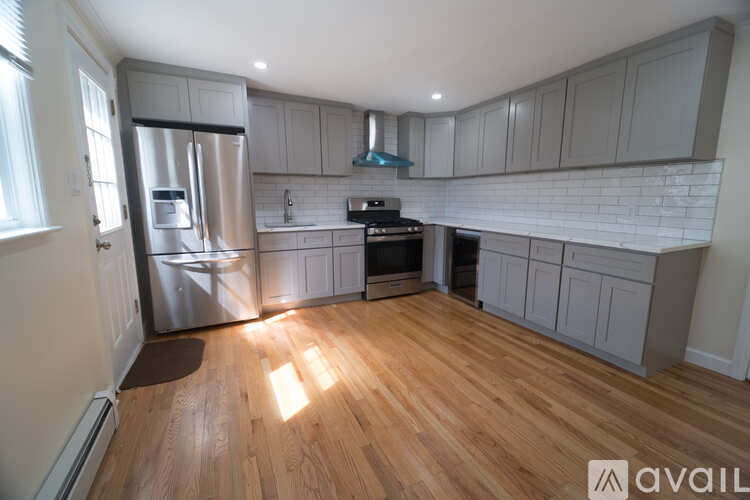 A kitchen with wooden floors and a refrigerator.