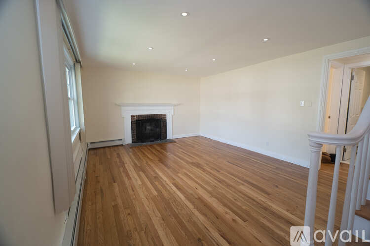 A room with wooden floors and a fireplace.