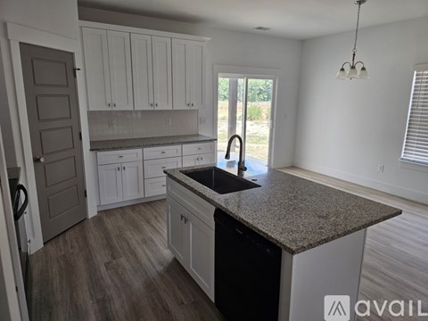 A kitchen with a granite countertop and white cabinets.
