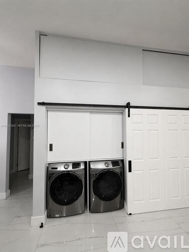 Two washing machines are placed in a garage.