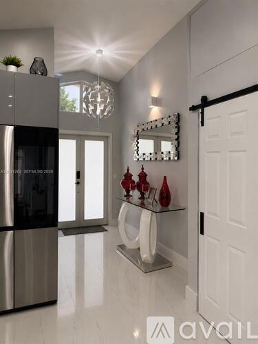 A modern kitchen with a stainless steel refrigerator and a glass shelf with red vases.