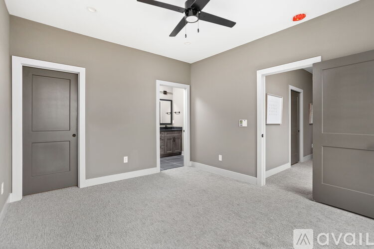 A spacious room with a ceiling fan and carpeted floor.