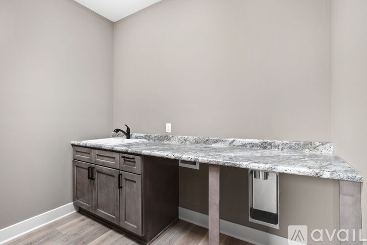 A kitchen island with a marble top and wooden cabinets.