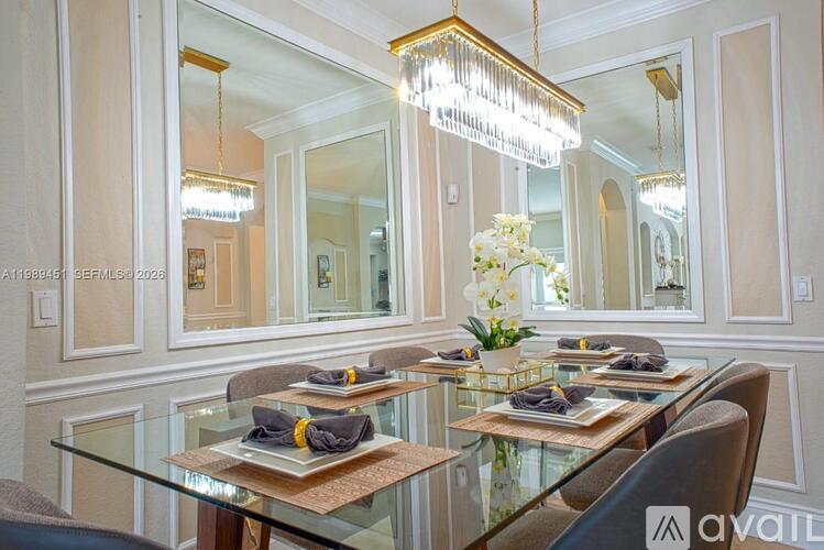 A dining room with a glass table set for two.