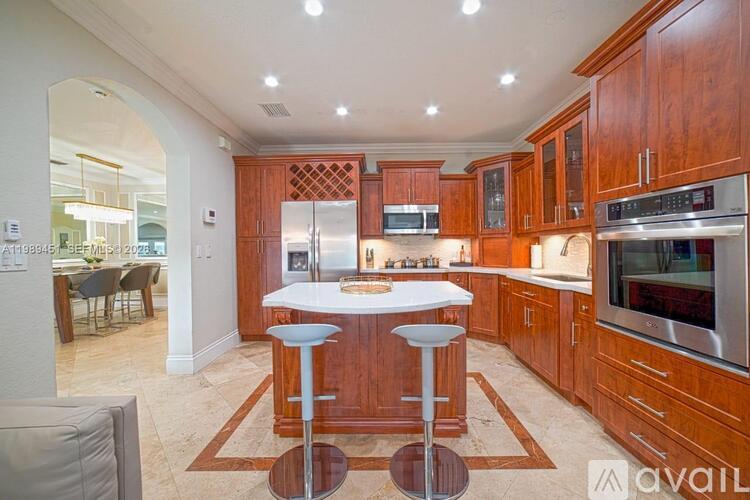 A kitchen with wooden cabinets and a white island.