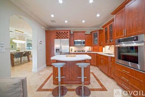 A kitchen with wooden cabinets and a white island.