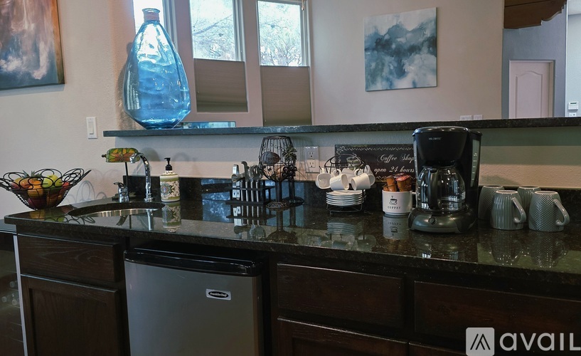 A kitchen counter with a coffee maker and a vase of flowers.