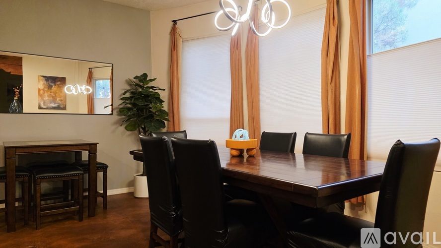 A dining room with a wooden table and black chairs.