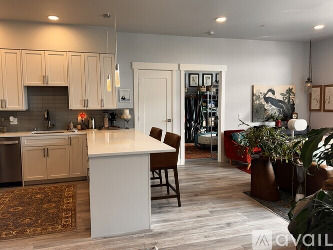 A kitchen with a white island and wooden floors.