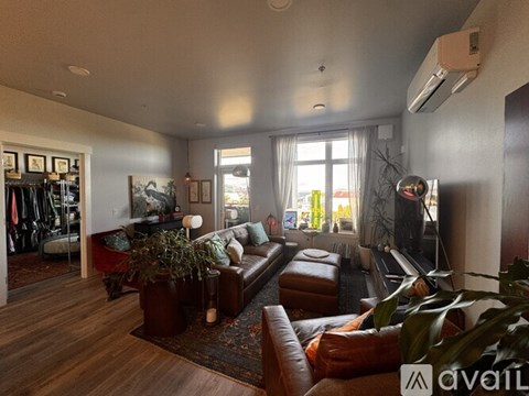 A living room with a brown leather couch and a rug.