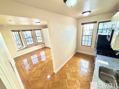 A kitchen with wooden floors and a refrigerator.