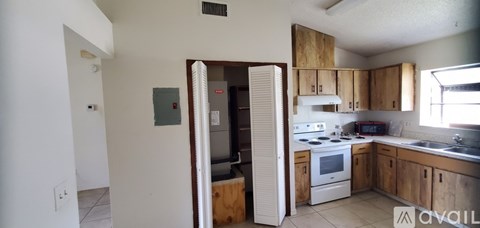 A kitchen with white appliances and wooden cabinets.