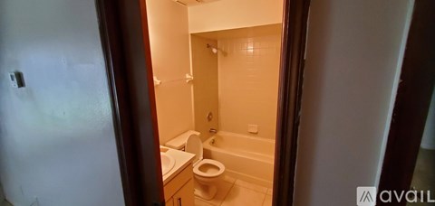 A bathroom with a toilet, sink and bathtub.